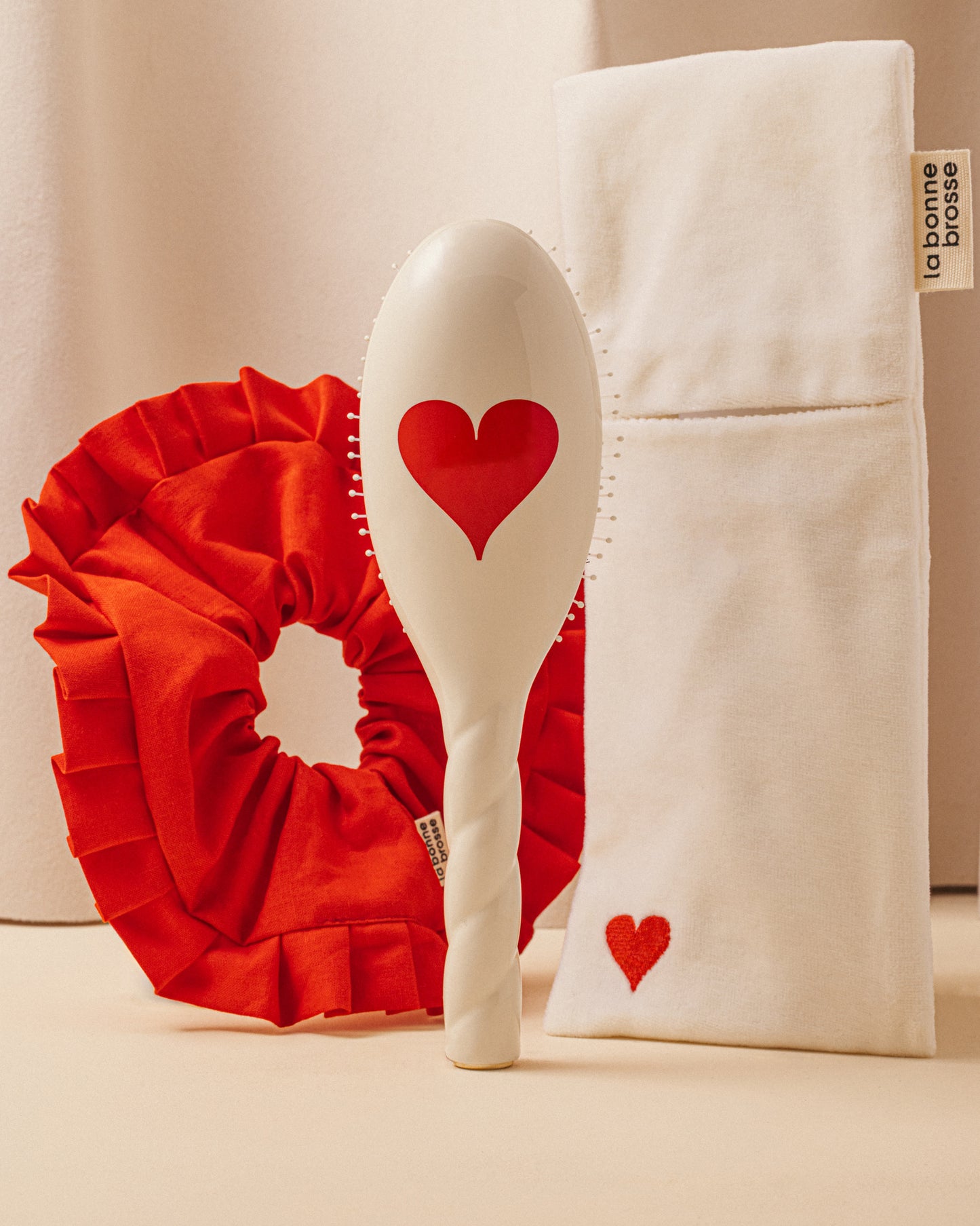 Trio: La Bonne Brosse, its Large Scrunchie, and its Limited Edition Queen of Hearts Pouch