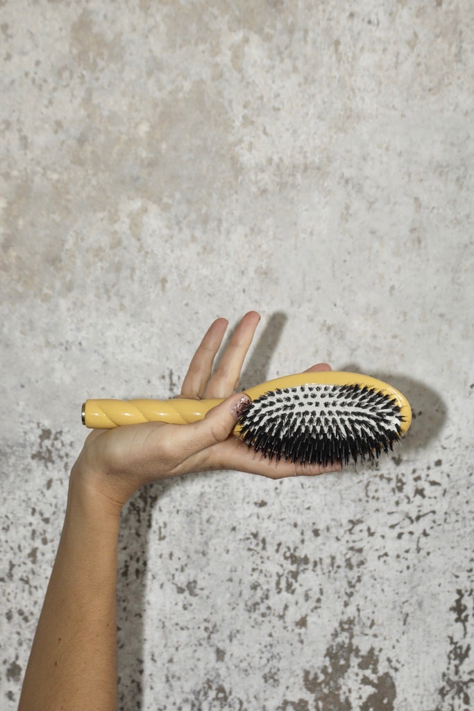 Brosse jaune dans une main